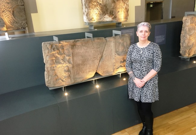 Dr Louisa Campbell with the Summerston distance stone at The Hunterian Museum 