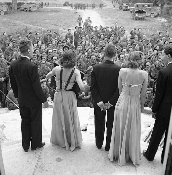 An ENSA concert party entertaining troops from the steps of a chateau in Normandy, 26 July 1944.